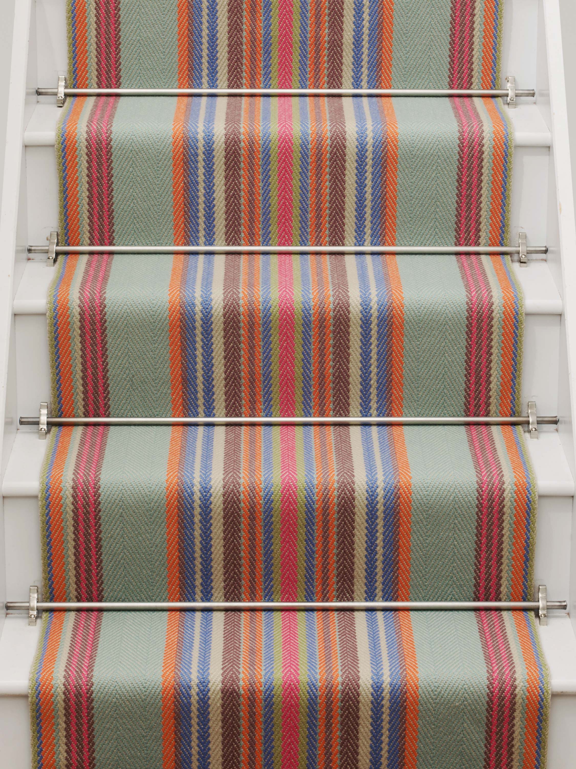 Striped flatweave runner in blue orange green and red on white staircase