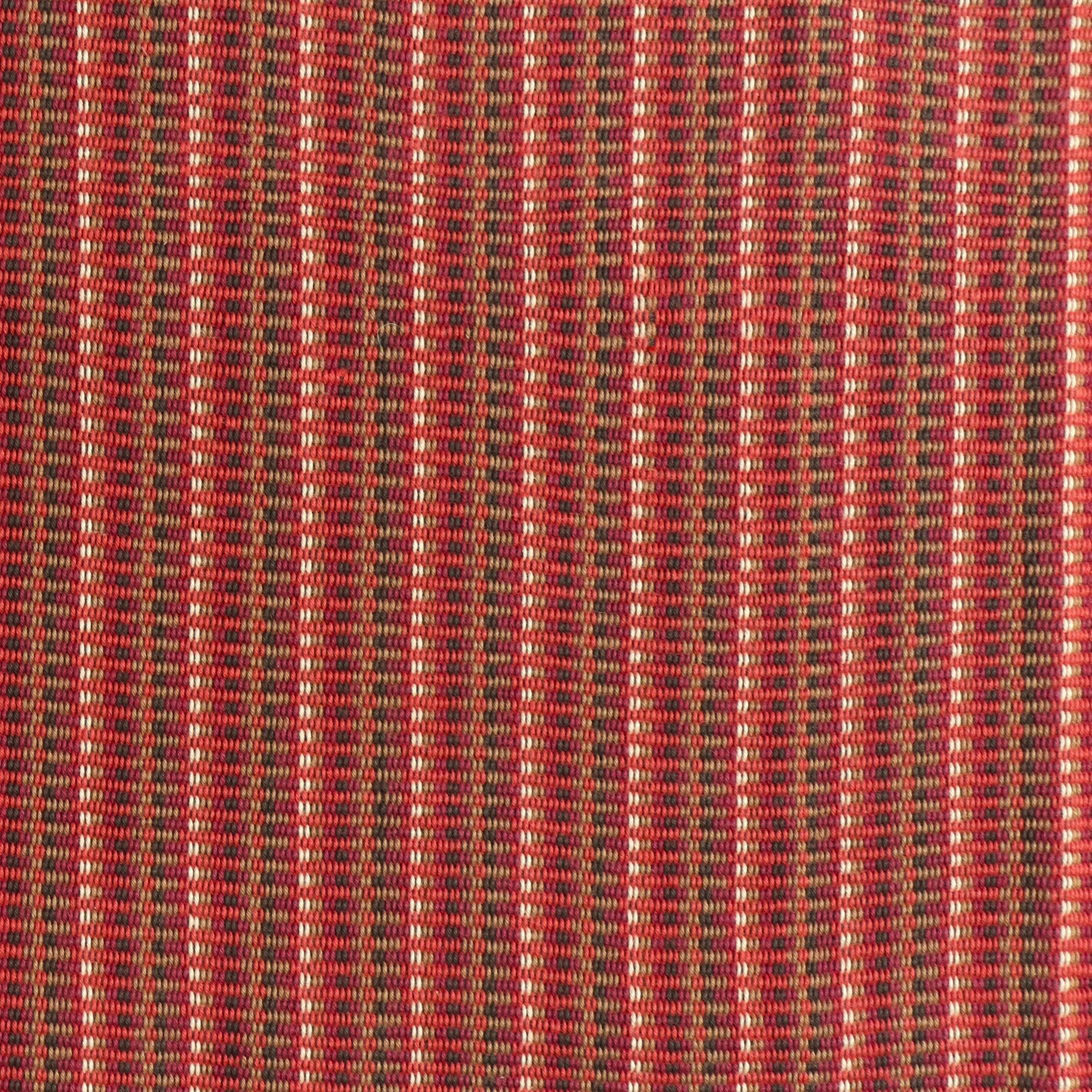 Detail of a hand-woven cotton fabric in an intricate stripe pattern in shades of red, maroon, navy and tan.