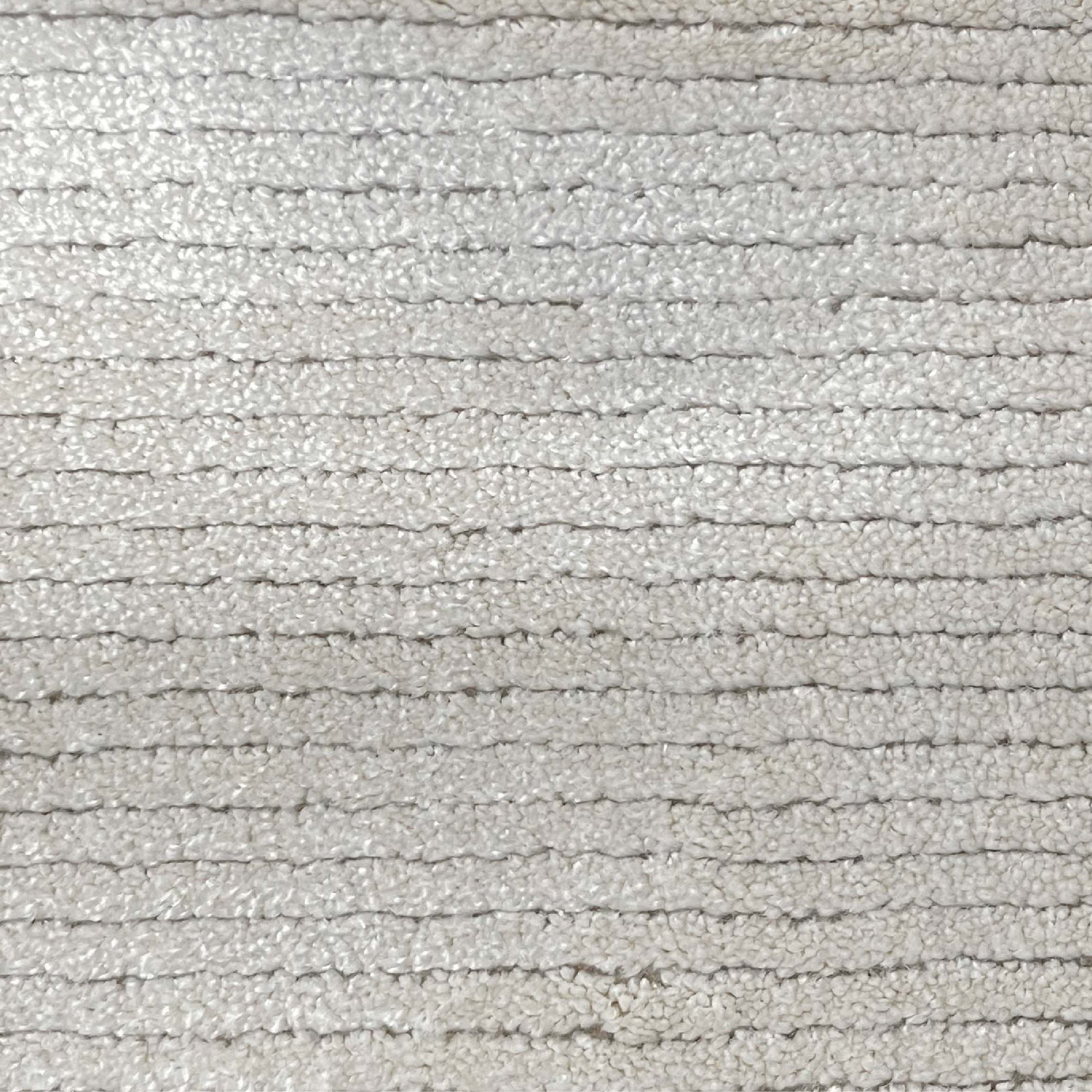 Broadloom carpet in a lightly ribbed cut pile in cool white. 