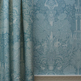 Teal patterned wallpaper with decorative design on a wall.