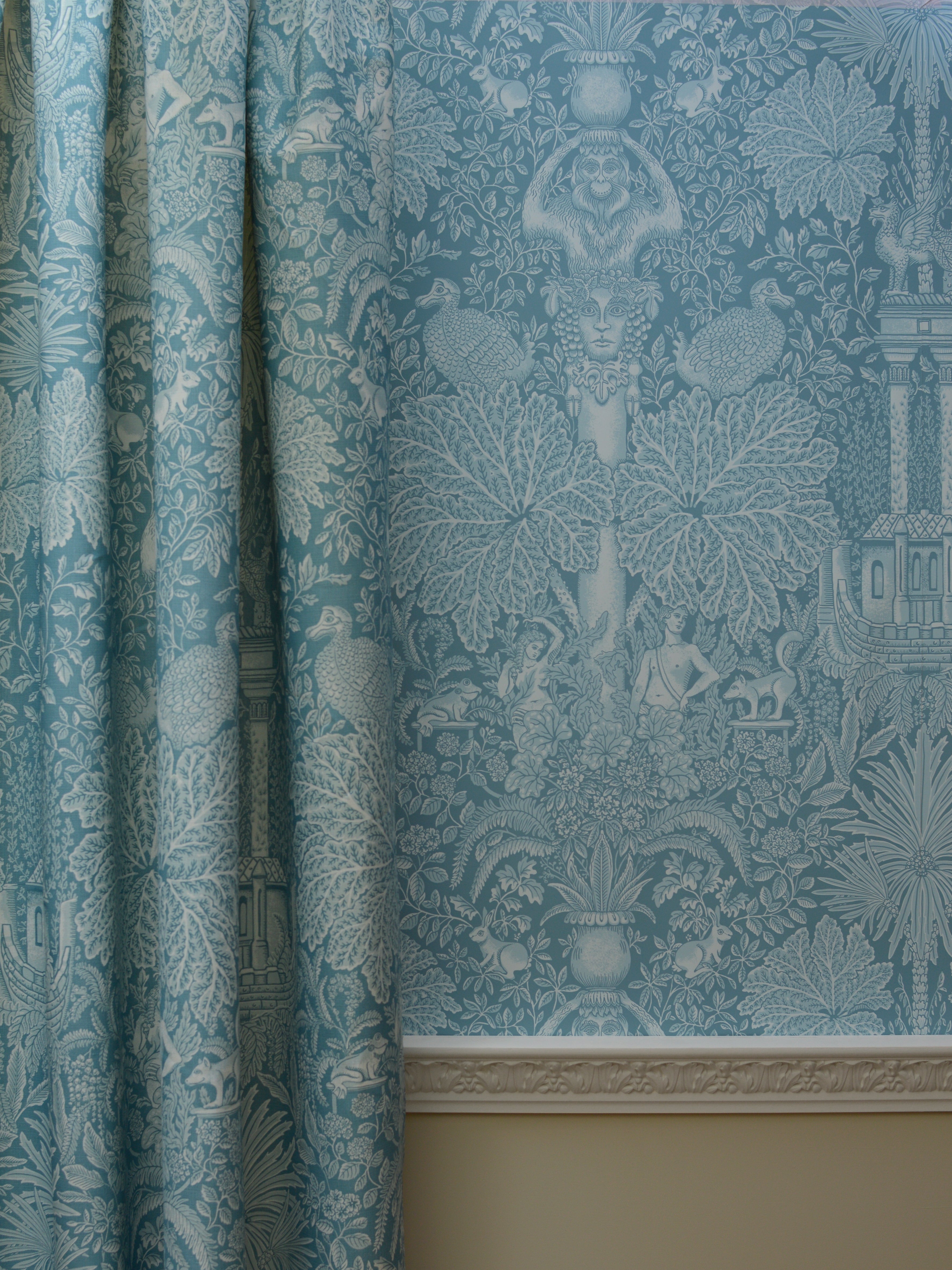 Teal patterned wallpaper with decorative design on a wall.