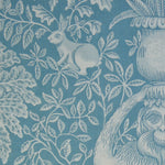 Decorative fabric with a botanical and animal pattern in shades of blue.