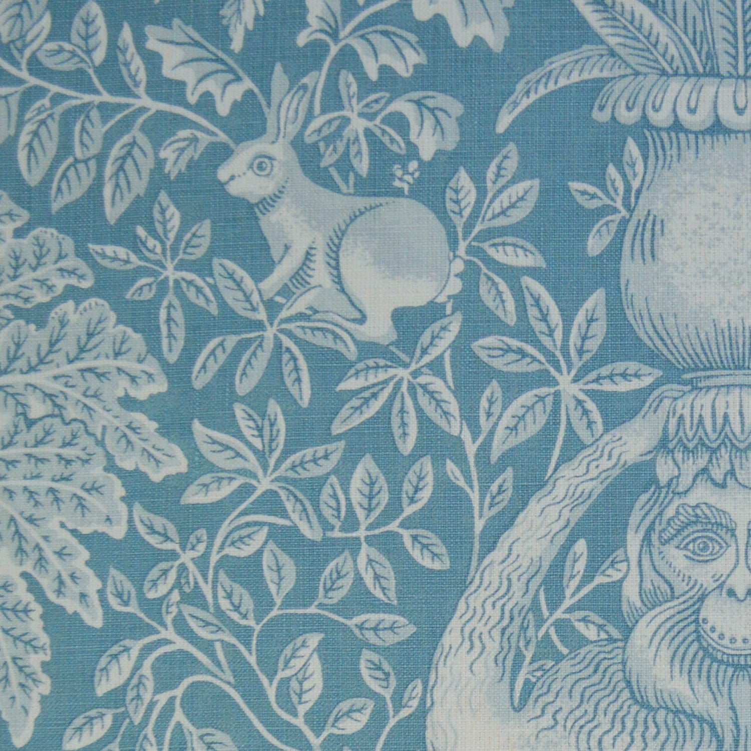 Decorative fabric with a botanical and animal pattern in shades of blue.