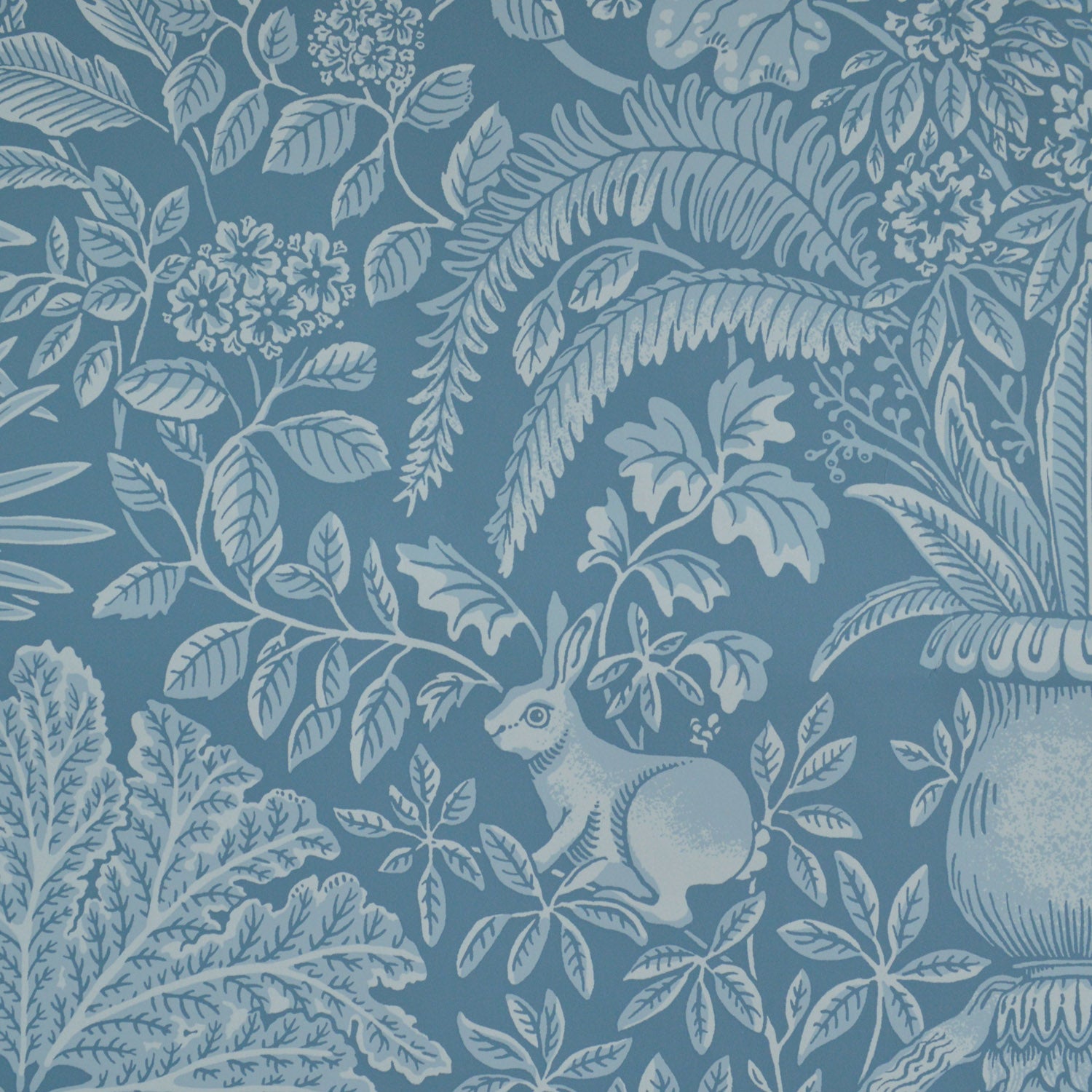 Patterned wallpaper with a rabbit and leaf design on a blue background