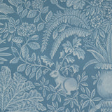 Patterned wallpaper with a rabbit and leaf design on a blue background