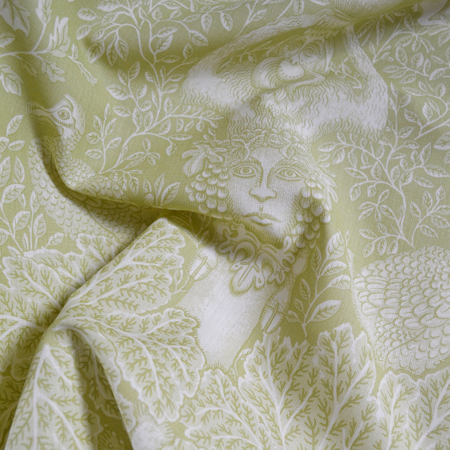 Fabric with intricate white floral and leaf pattern on a light green background