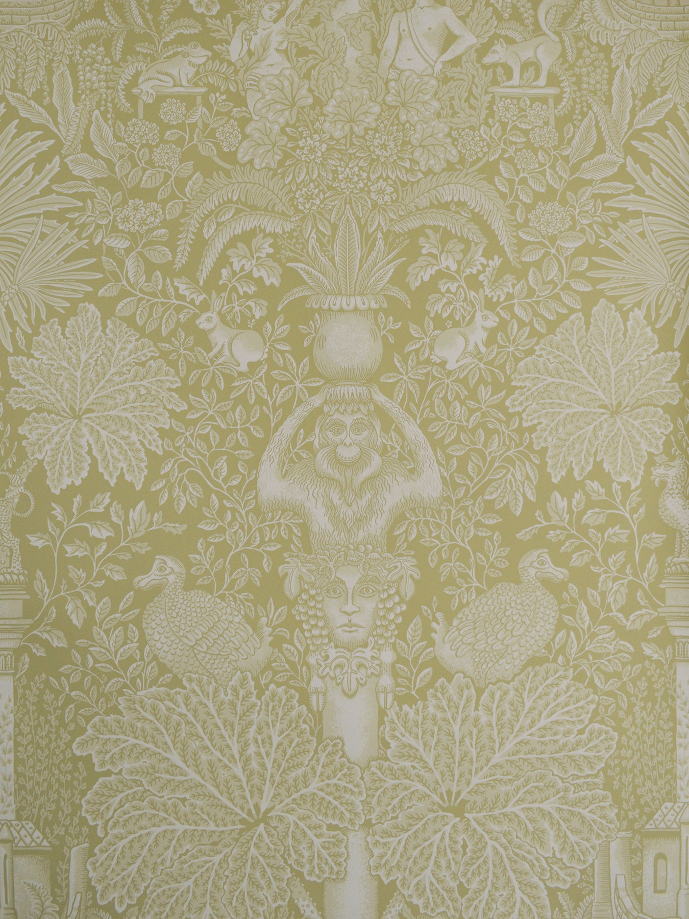 Decorative wallpaper with intricate patterns of leaves, flowers, and classical elements on a green background.