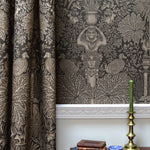 Decorative curtain with intricate patterns and a candlestick holder on a table.