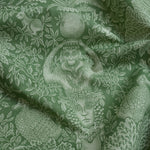 Green fabric with classical design featuring a woman's head, monkey, and peacock.