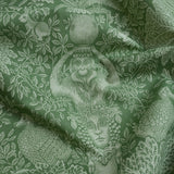 Green fabric with classical design featuring a woman's head, monkey, and peacock.