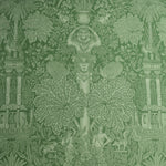Decorative fabric pattern with classical elements and foliage on a green background