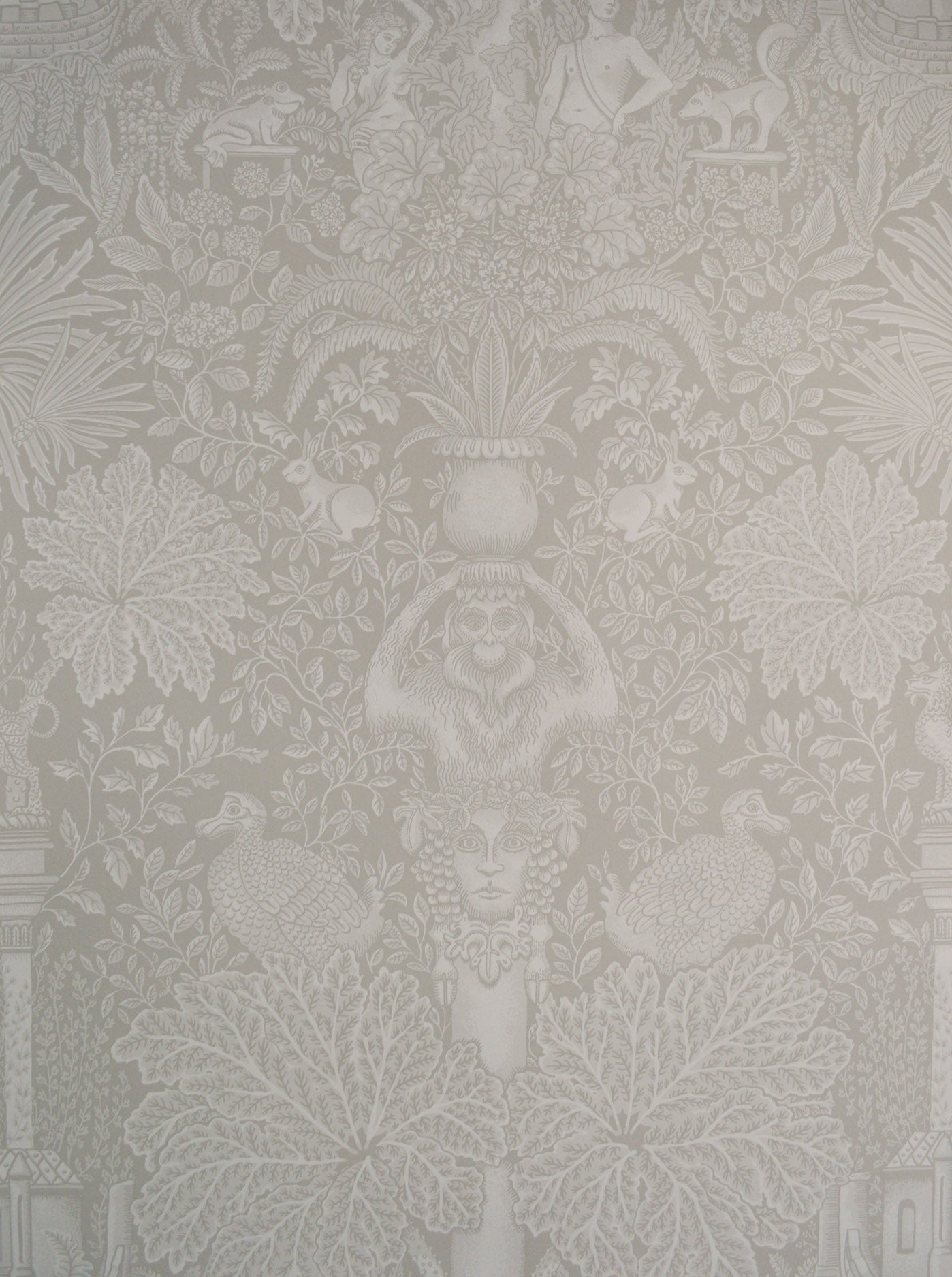 Decorative wallpaper with intricate floral and leaf patterns in a neutral color.