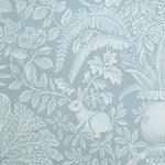 Patterned wallpaper with white leaves and a rabbit on a blue background