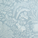 Patterned wallpaper with white leaves and a rabbit on a blue background