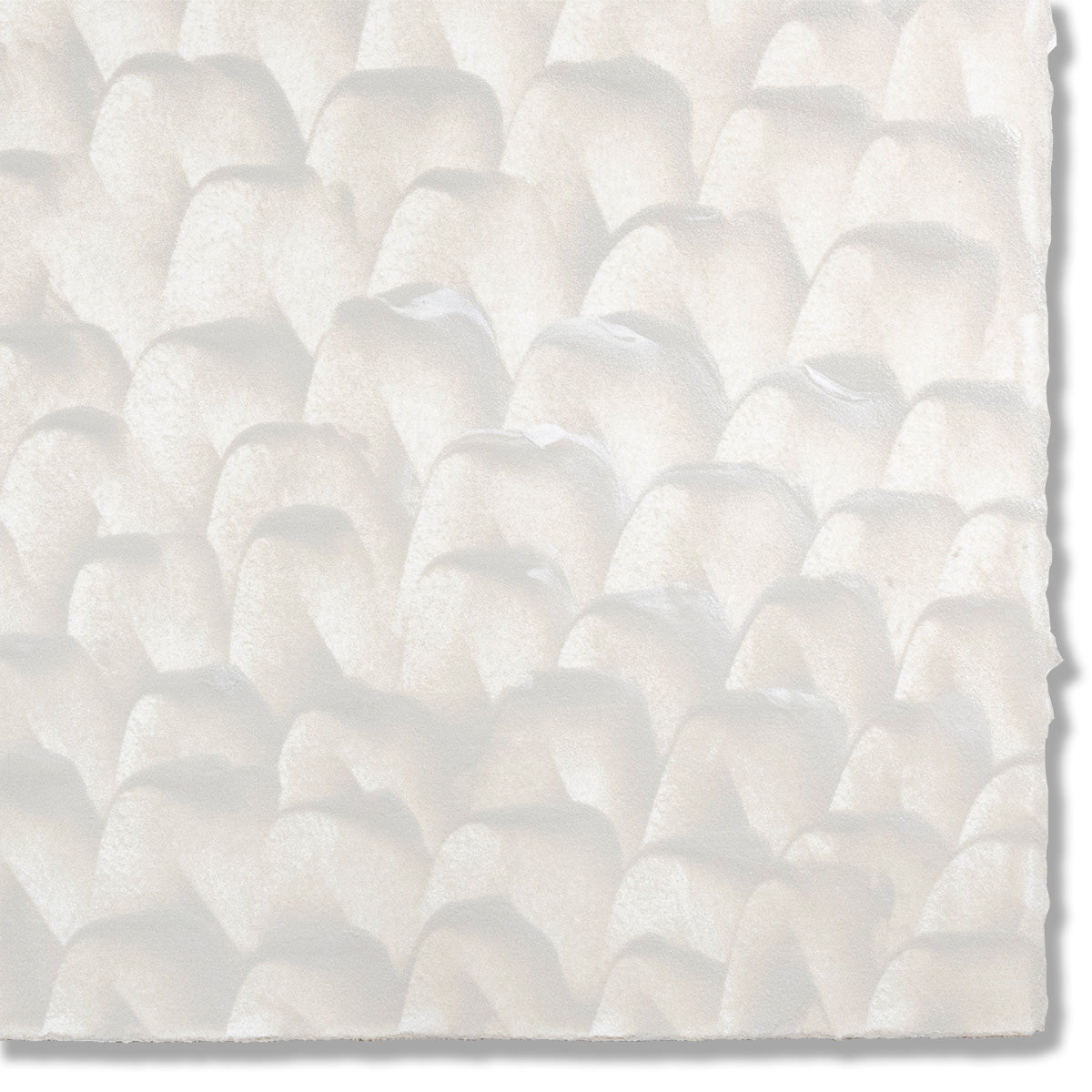 Detail of a hand-painted wallpaper swatch with a repeating dappled texture in cream.