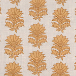 Detail of fabric in a repeating thistle print in orange and rust on a cream field.