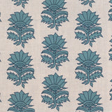 Detail of fabric in a repeating thistle print in navy and turquoise on a cream field.