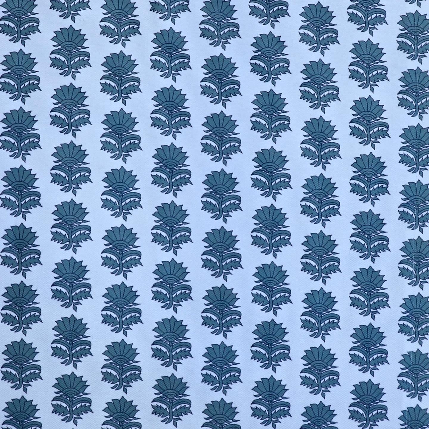 Detail of fabric in a repeating thistle print in navy and turquoise on a light blue field.