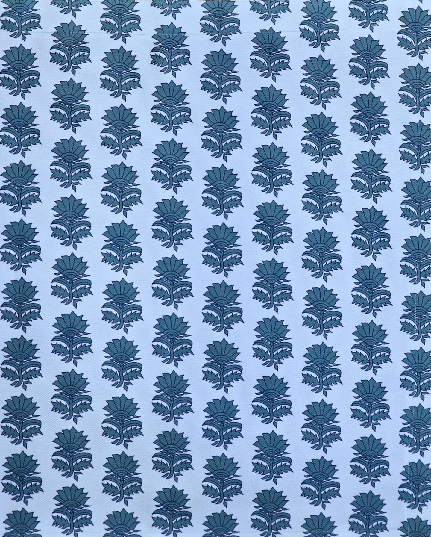 Detail of fabric in a repeating thistle print in navy and turquoise on a light blue field.