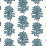 Detail of fabric in a repeating thistle print in navy and turquoise on a white field.