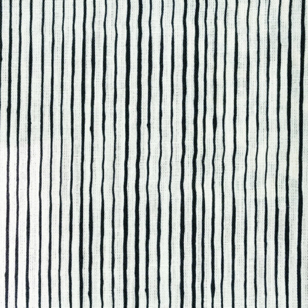 Fabric in a painterly stripe pattern in black on a white field.