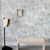 A modernist living tableau with a wall papered in a watercolor painted print in blue, green, yellow and white.