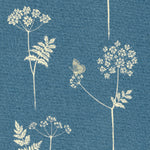 Detail of fabric in a playful flower and butterfly print in cream on a blue field.