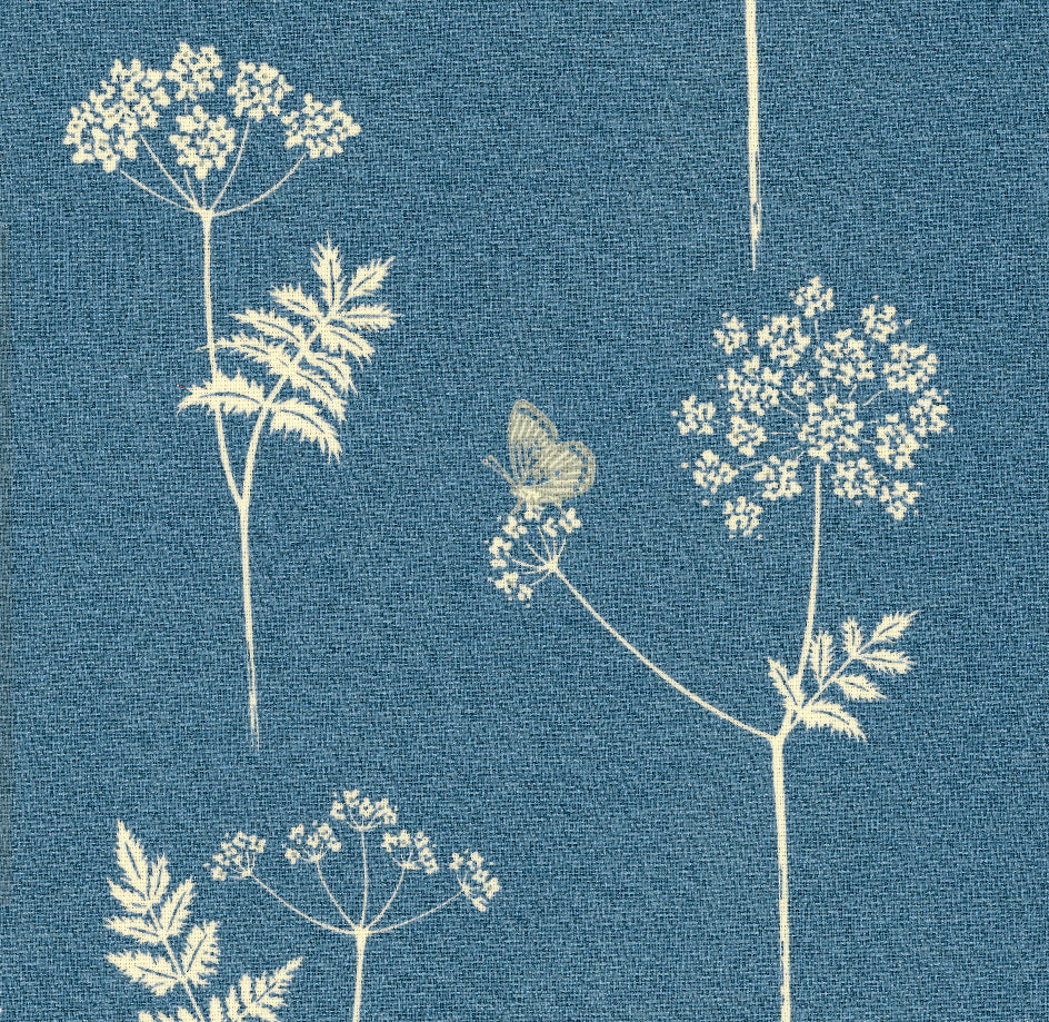 Detail of fabric in a playful flower and butterfly print in cream on a blue field.