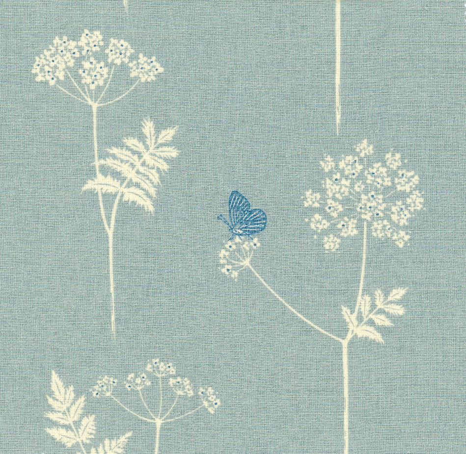 Detail of fabric in a playful flower and butterfly print in cream and blue on a light blue field.