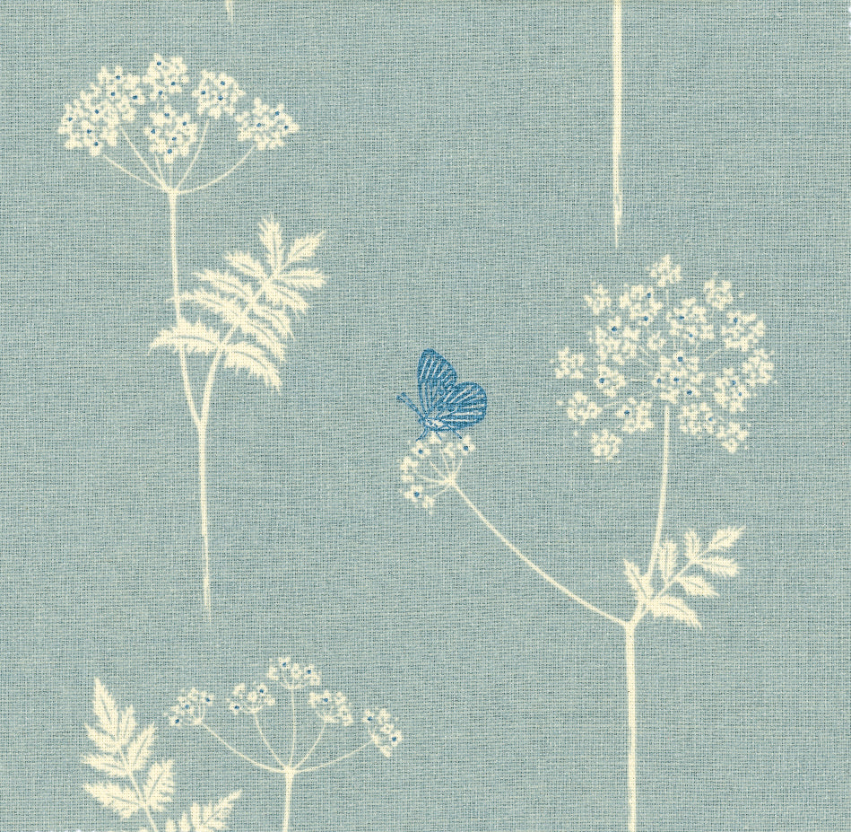 Detail of fabric in a playful flower and butterfly print in cream and blue on a light blue field.