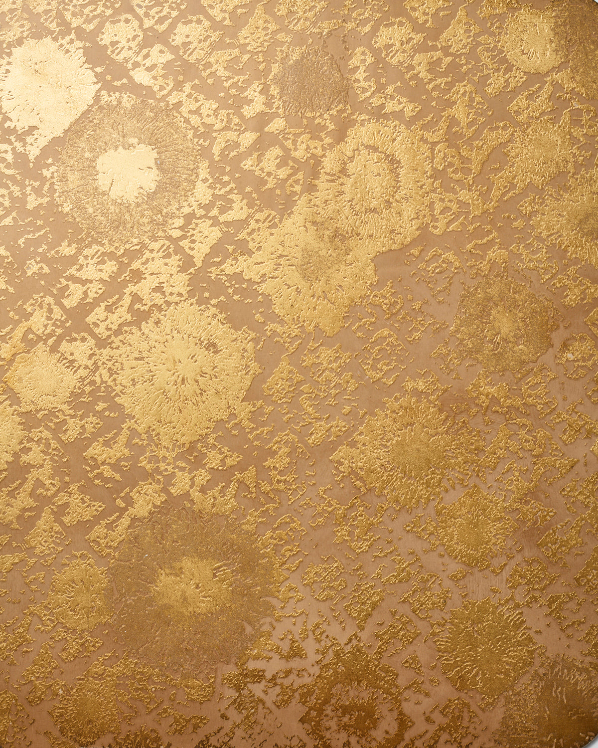 Detail of wallpaper in a textural botanical print in metallic gold on a brown field.