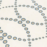 Fabric yardage in a playful floral lattice print in yellow and navy on a cream field.