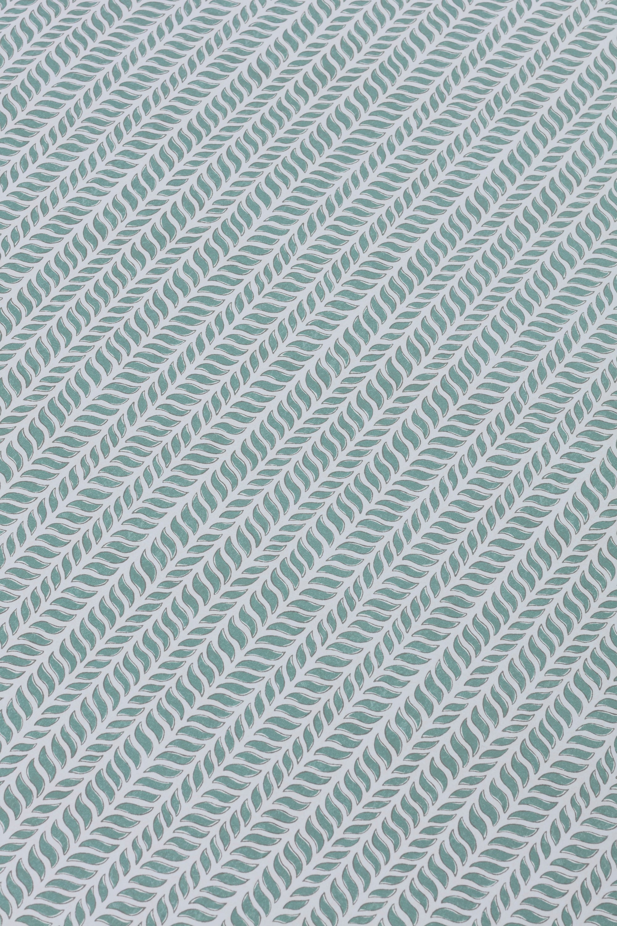 Detail of a wallpaper panel in a painterly herringbone print in turquoise on a light blue field.