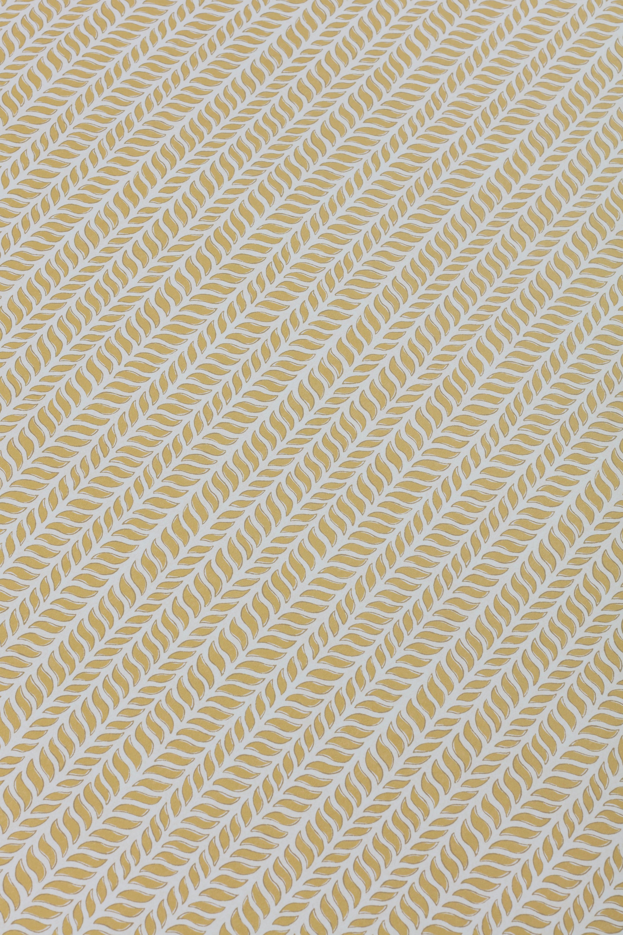 Detail of a wallpaper panel in a painterly herringbone print in yellow on a light blue field.