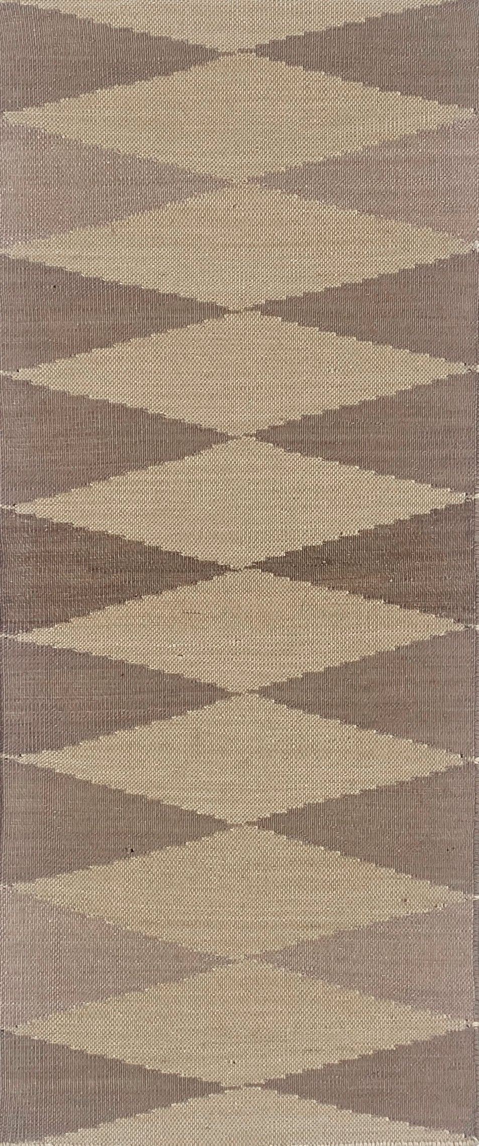Geometric patterned rug with diamond shapes in brown and beige tones