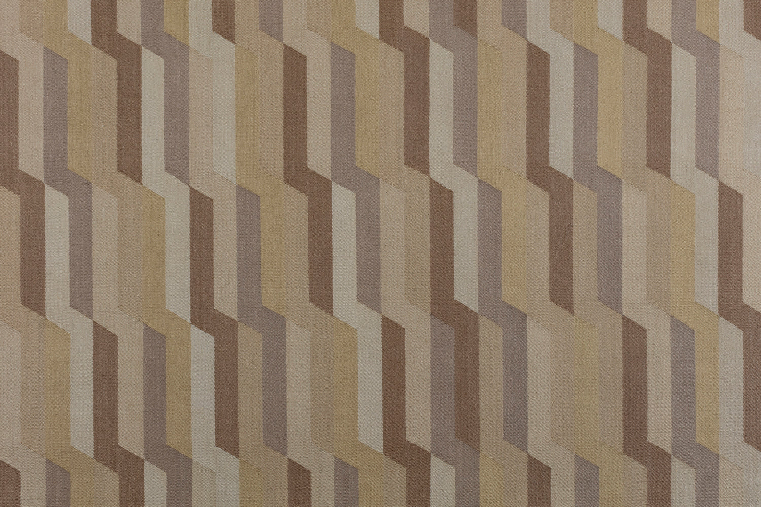 Detail of a handwoven rug with a stacked zig zag stripe in shades of brown, taupe, and tan. 