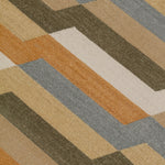 Detail of a handwoven rug with a stacked zig zag stripe in shades of tan, ochre, chambray blue and ivory. 
