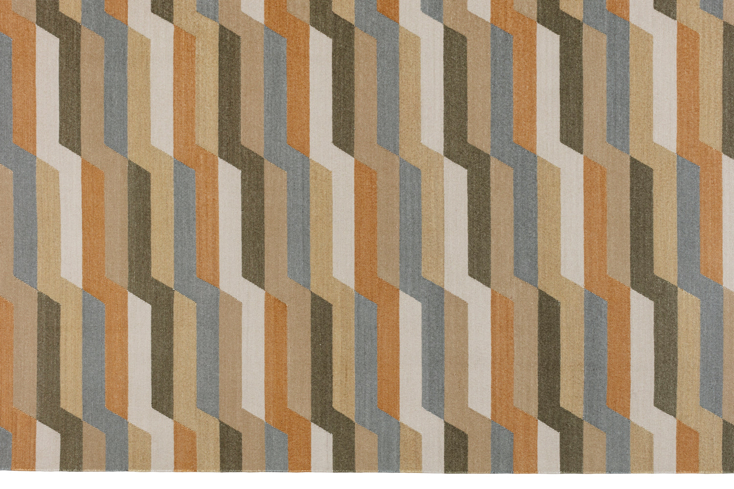 Detail of a handwoven rug with a stacked zig zag stripe in shades of tan, ochre, chambray blue and ivory. 