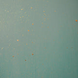 Detail of a wallpaper in a random splattered pattern in metallic gold on a green field.