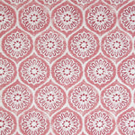 Detail of fabric in a floral lattice print in pink and red on a cream field.