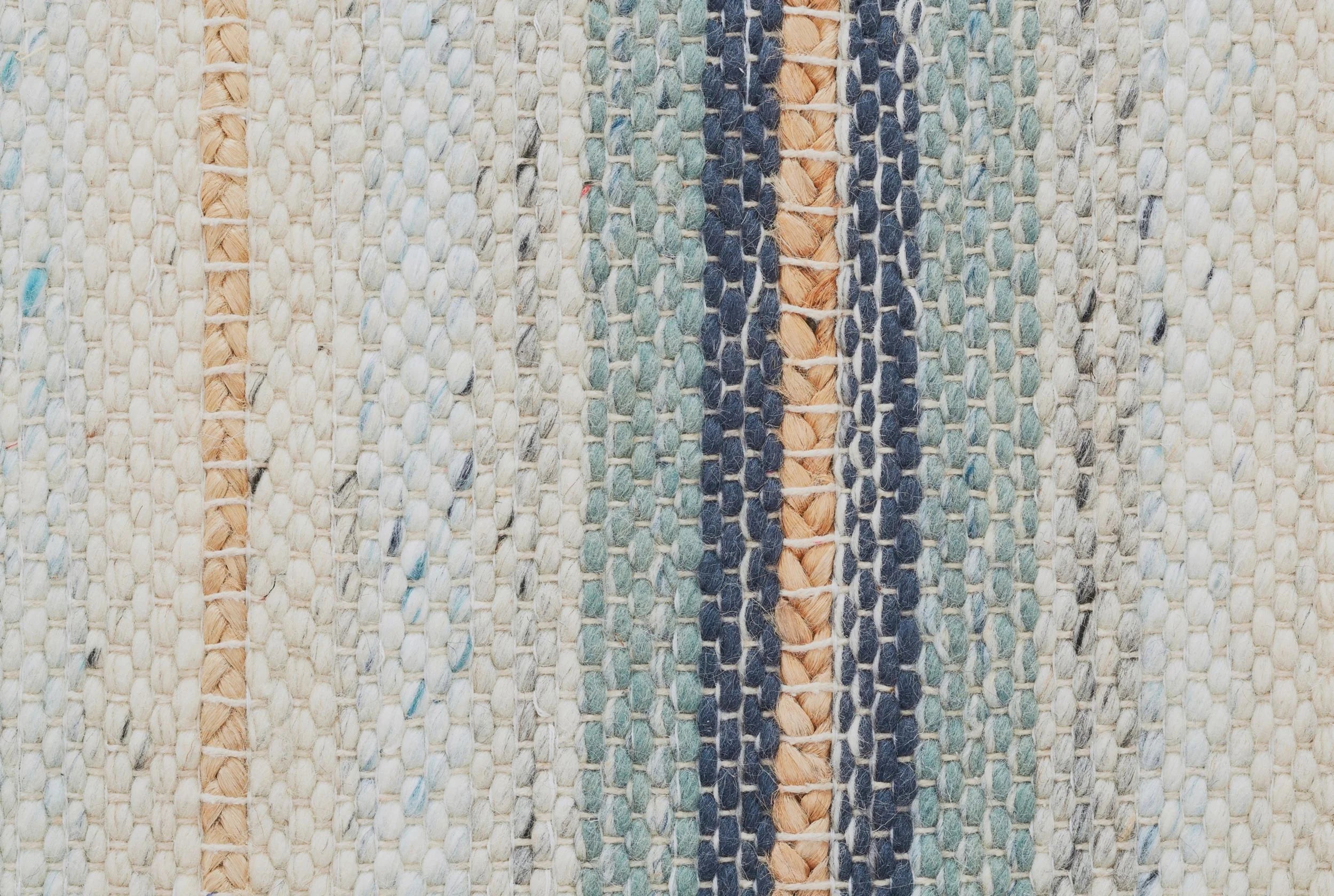 Close-up of a broadloom carpet fabric with stripes in teal, navy, beige and tan. 