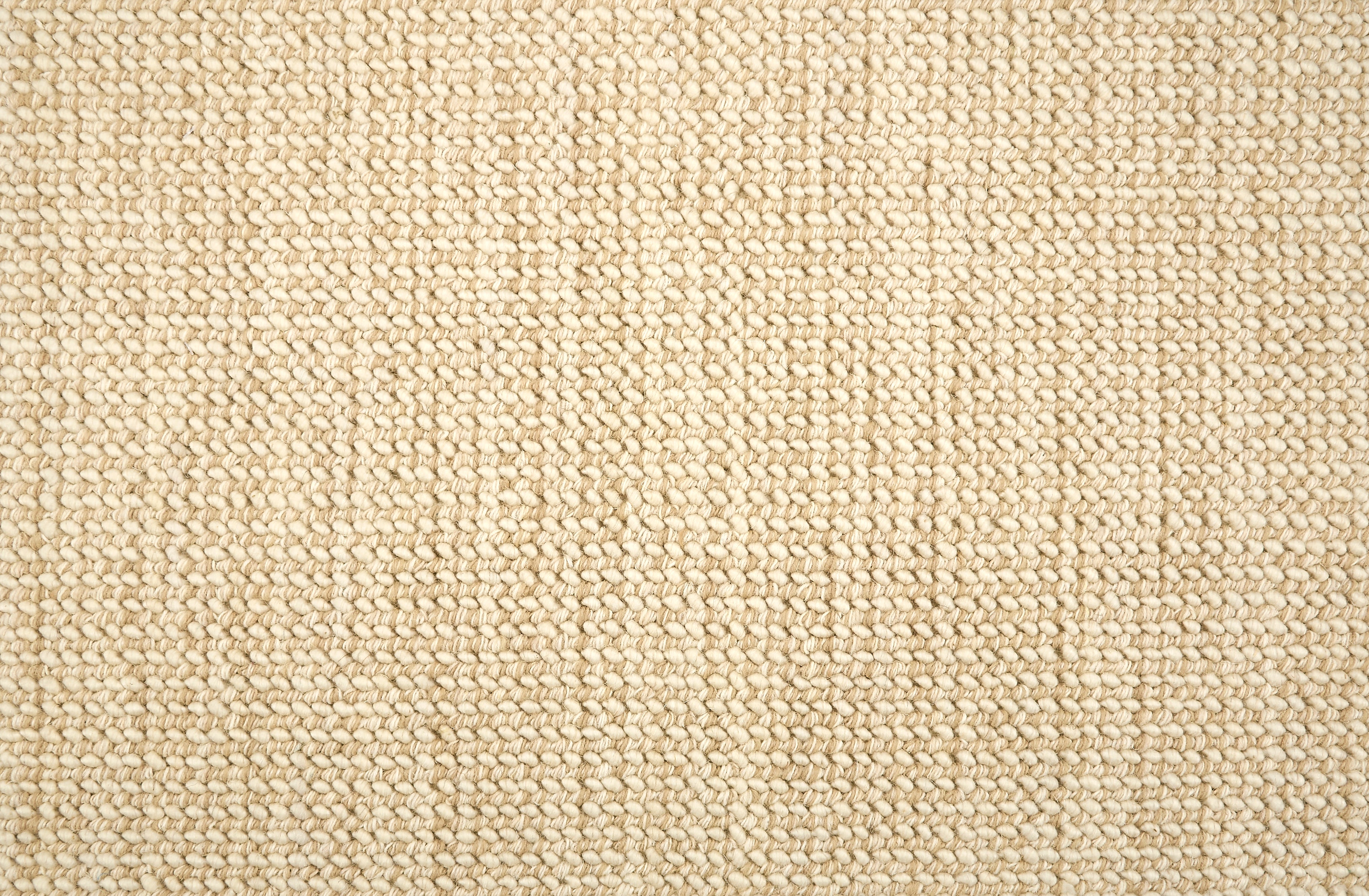 A close-up of a broadloom carpet with a woven texture in cream and beige. 