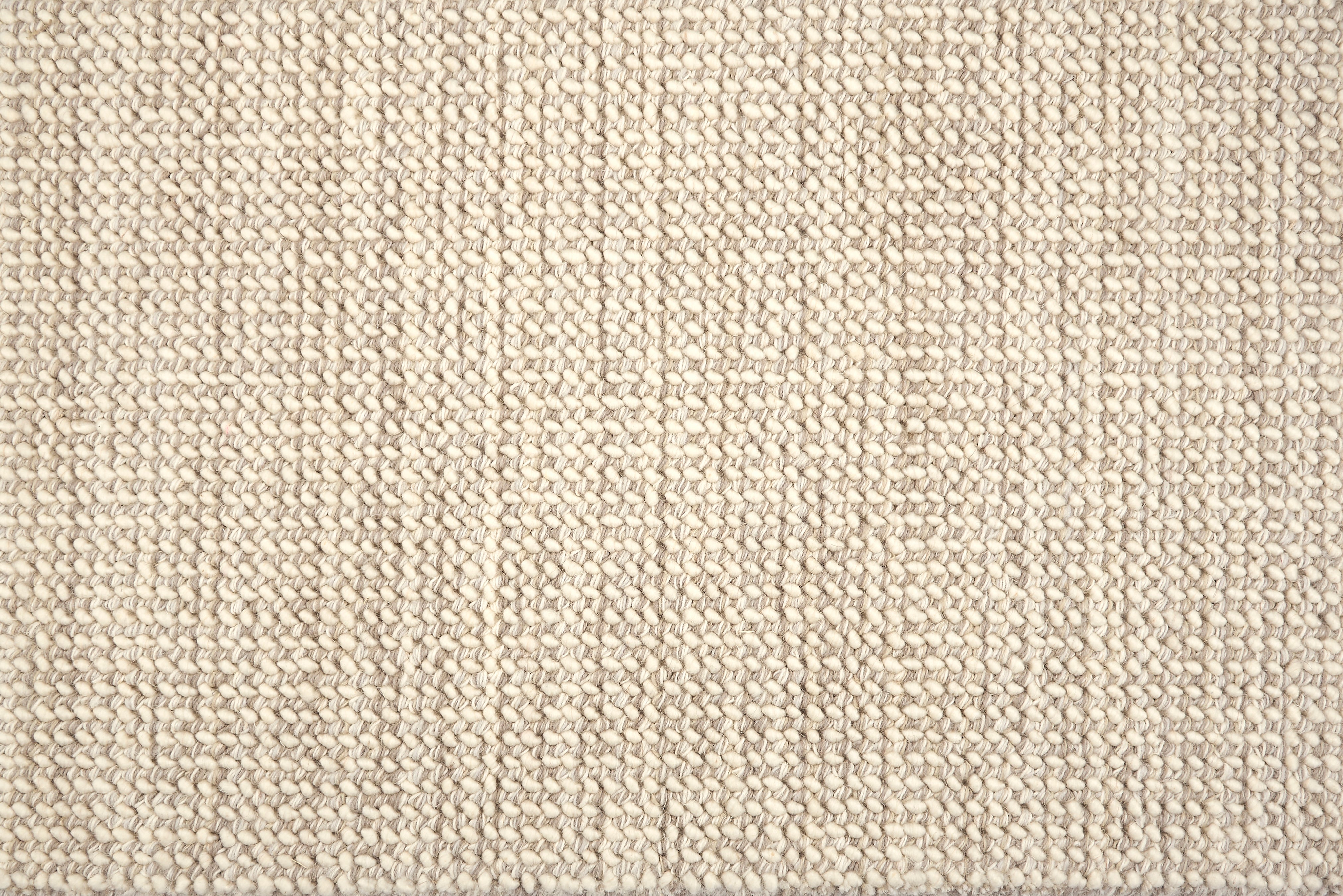 A close-up of a broadloom carpet with a woven texture in cream and ecru. 