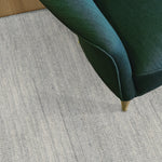 Green chair corner on a textured light gray carpet