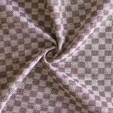 Close up of draped woven fabric with small scale checkerboard pattern in white and dark brown.