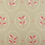 Detail of fabric in a repeating leaf print in red and cream on a light brown field.