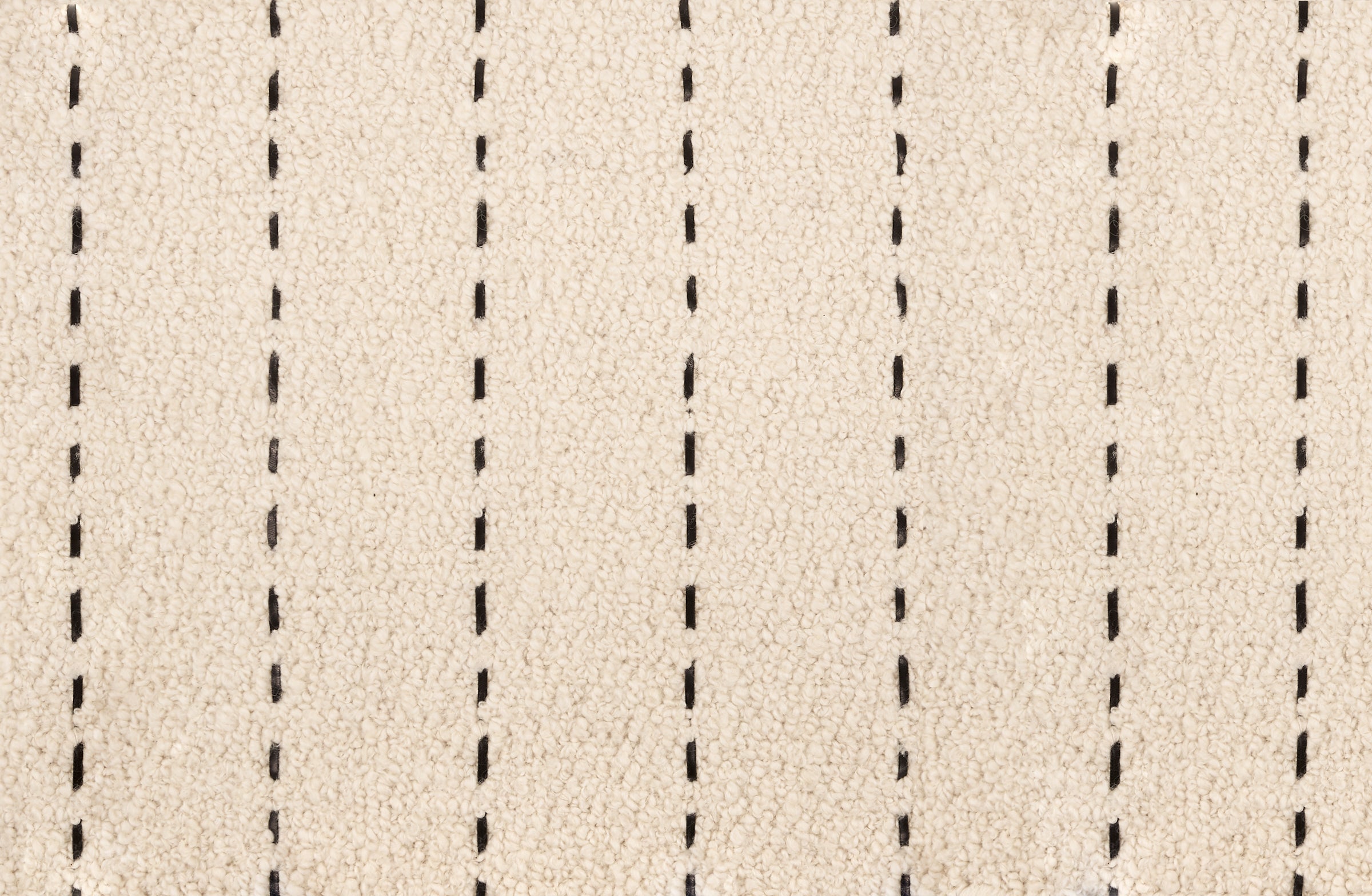 Broadloom carpet with a thin dashed stripe in black leather on a cream field.