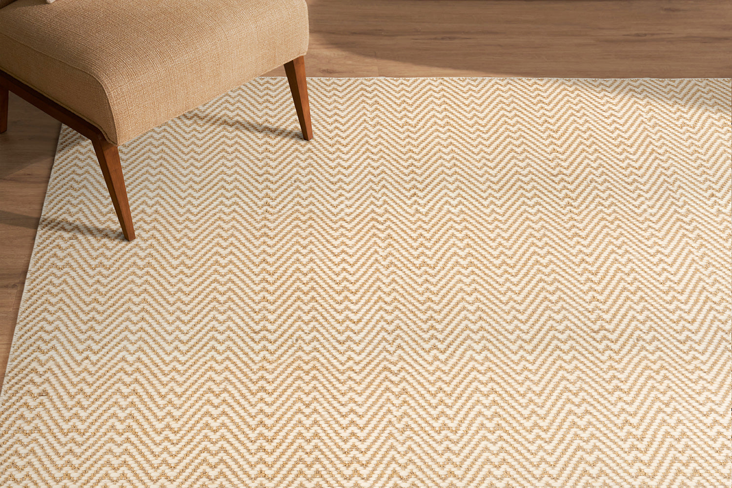Beige zigzag patterned rug on a wooden floor with a chair partially visible.