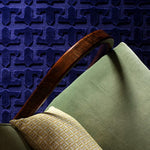 Green upholstered side chair against a textured blue carpet