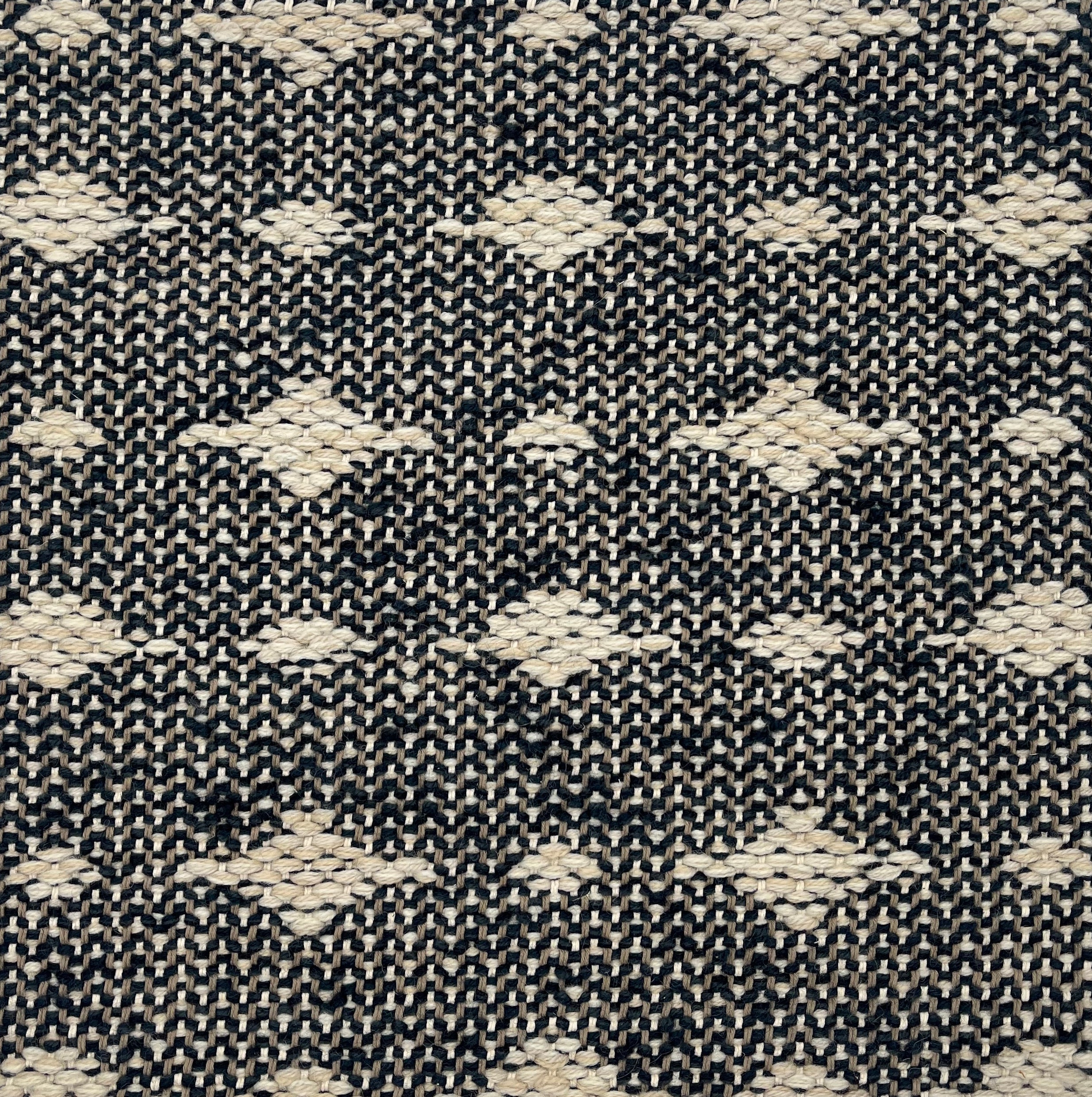 Handwoven rug detail in a contemporary spotted design in black and white